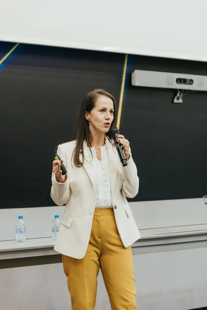A speaker presenting with microphone and clicker in hand