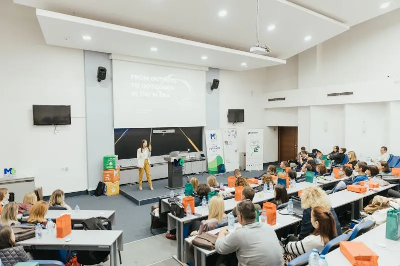 A speaker on stage before a full hall at the annual conference